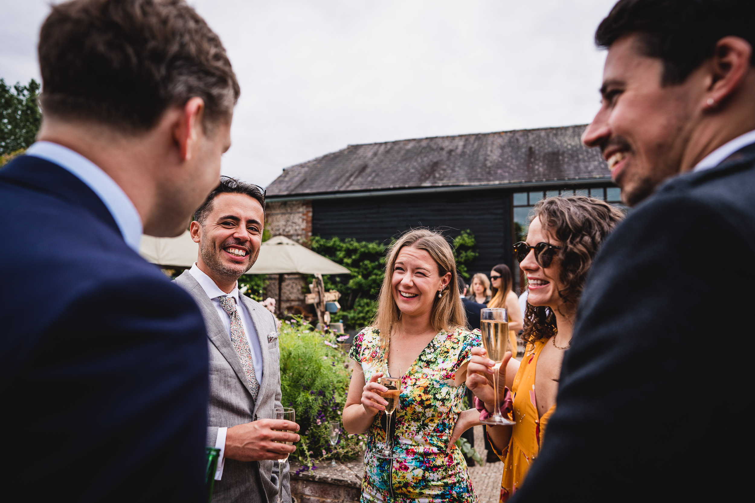 Group of people in formal attire smiling and talking outdoors.