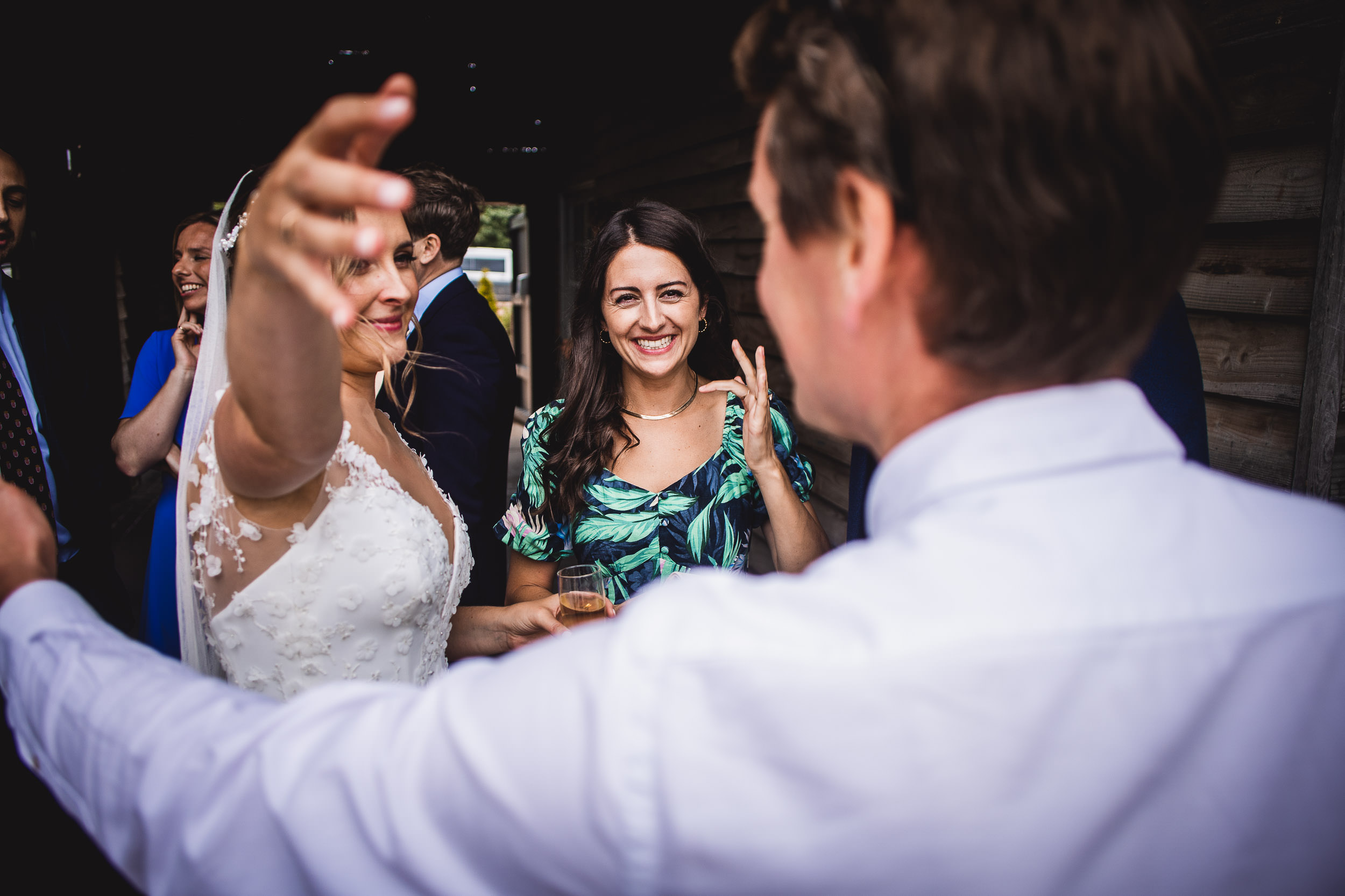 Bride and guests smiling and interacting at a wedding reception.